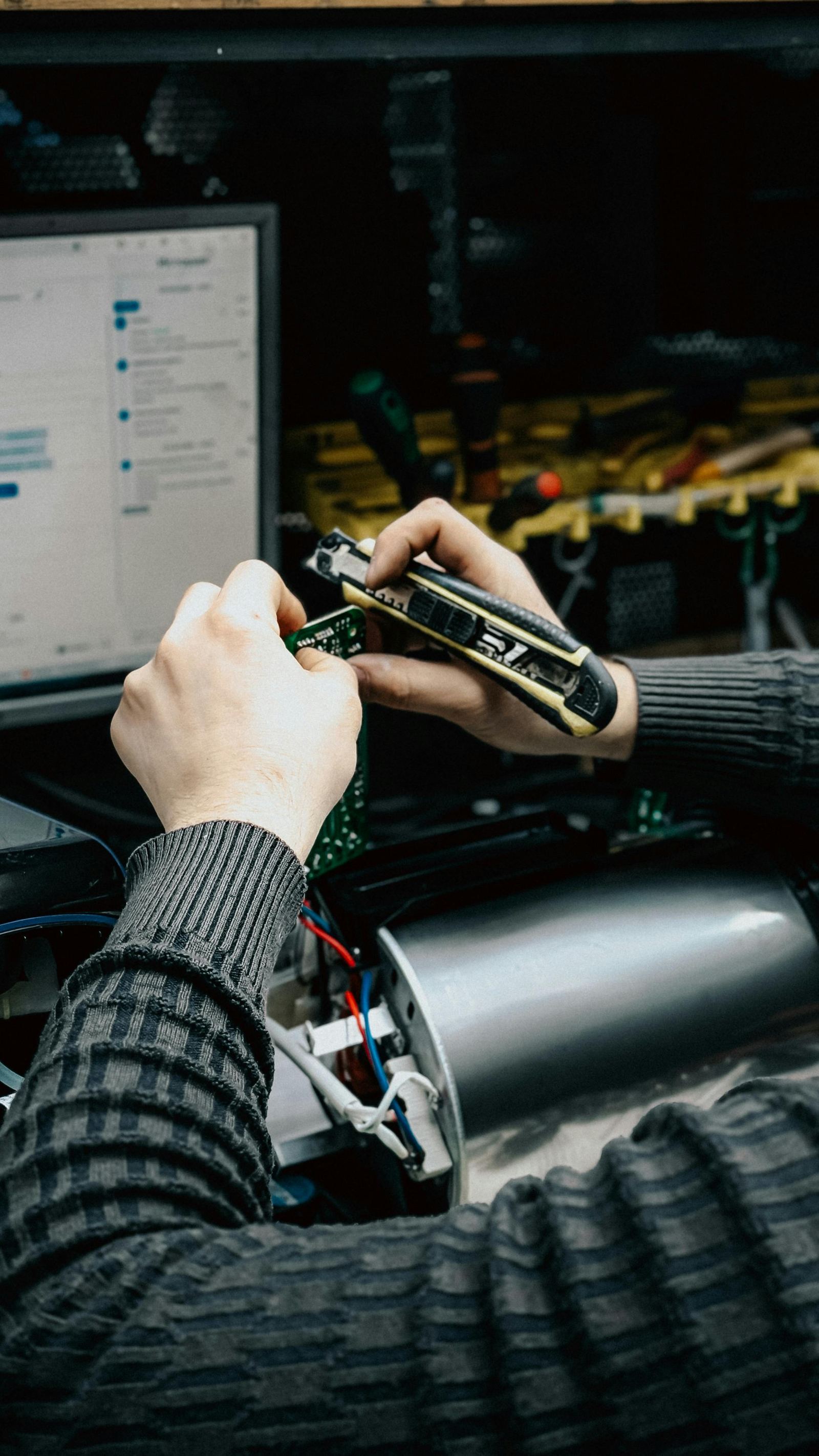 Hands working on electronics and computer repair